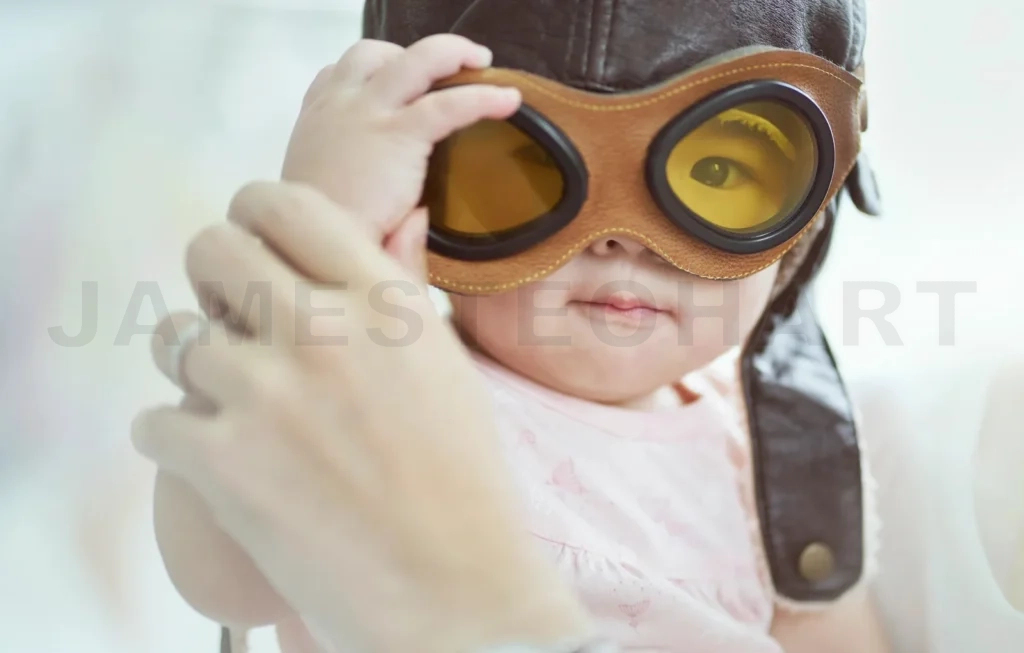 
Baby trying on aviator goggles and pilot hat