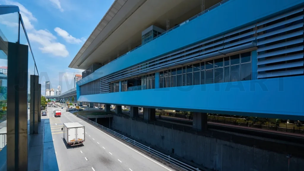 
Blue elevated train station with urban highway traffic