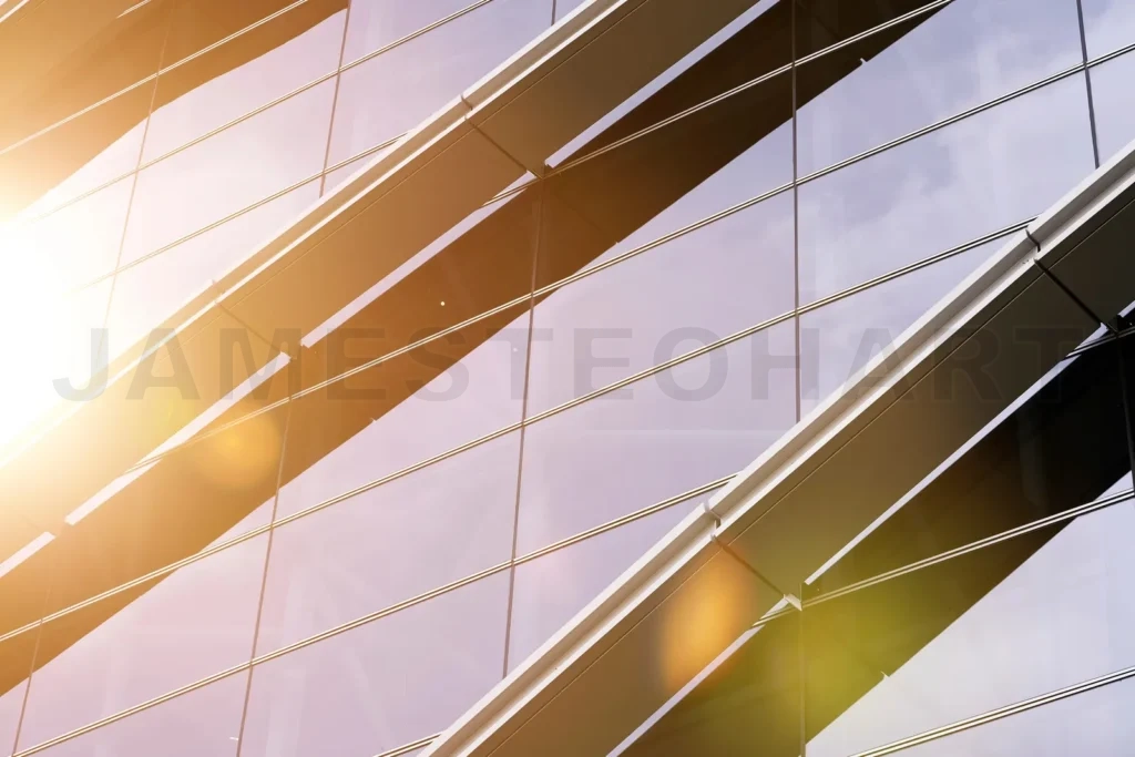 
Modern office building glass facade reflecting sunny sky