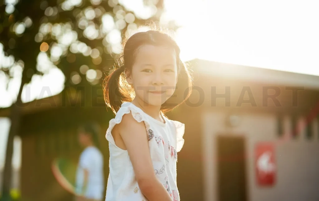 
Little girl smiling outdoors during sunset