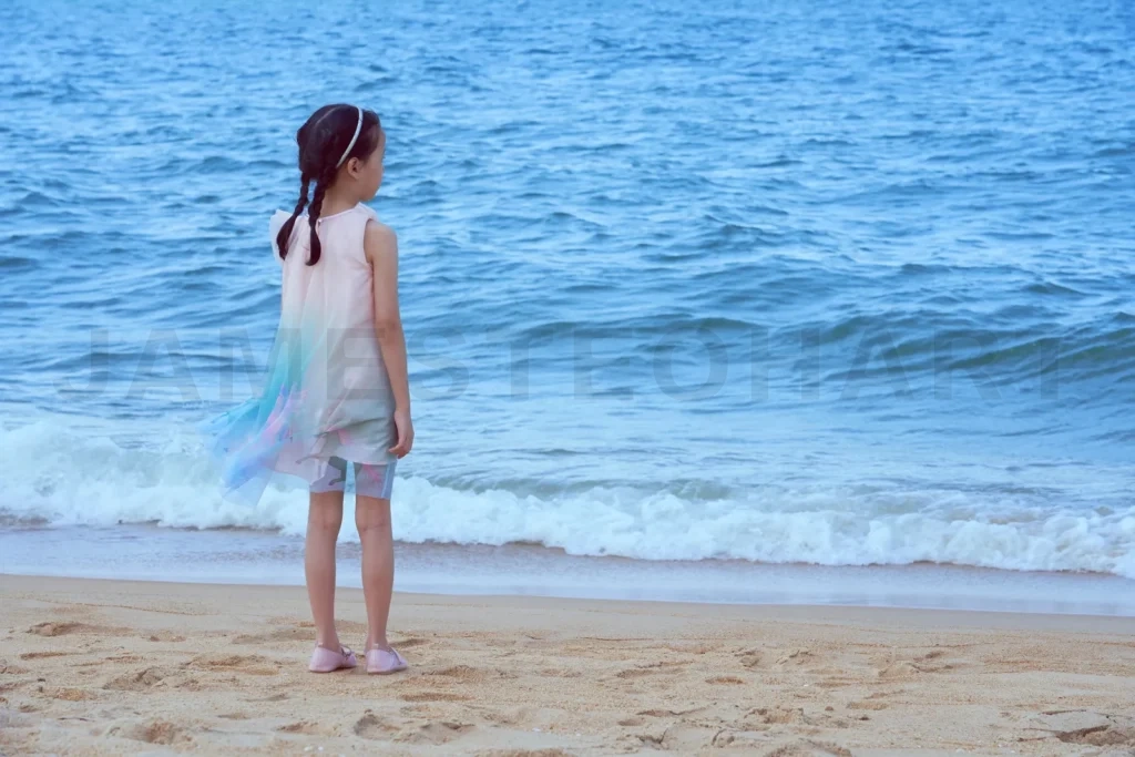 
Lovely asian little girl in a pink shirt on tropical beach