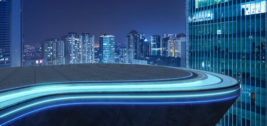 
High-Angle View Of A Sleek, Empty Rooftop Platform With A Curved Track, Glowing Blue Led Lights, And A Cityscape Backdrop At Night