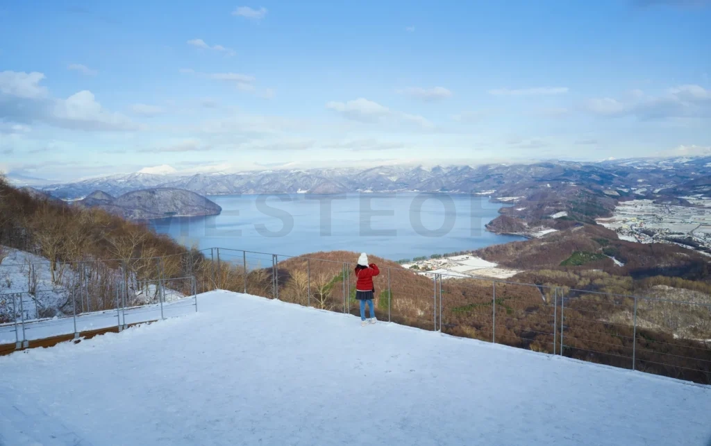 
Little girl admiring winter landscape overlooking lake toya japan
