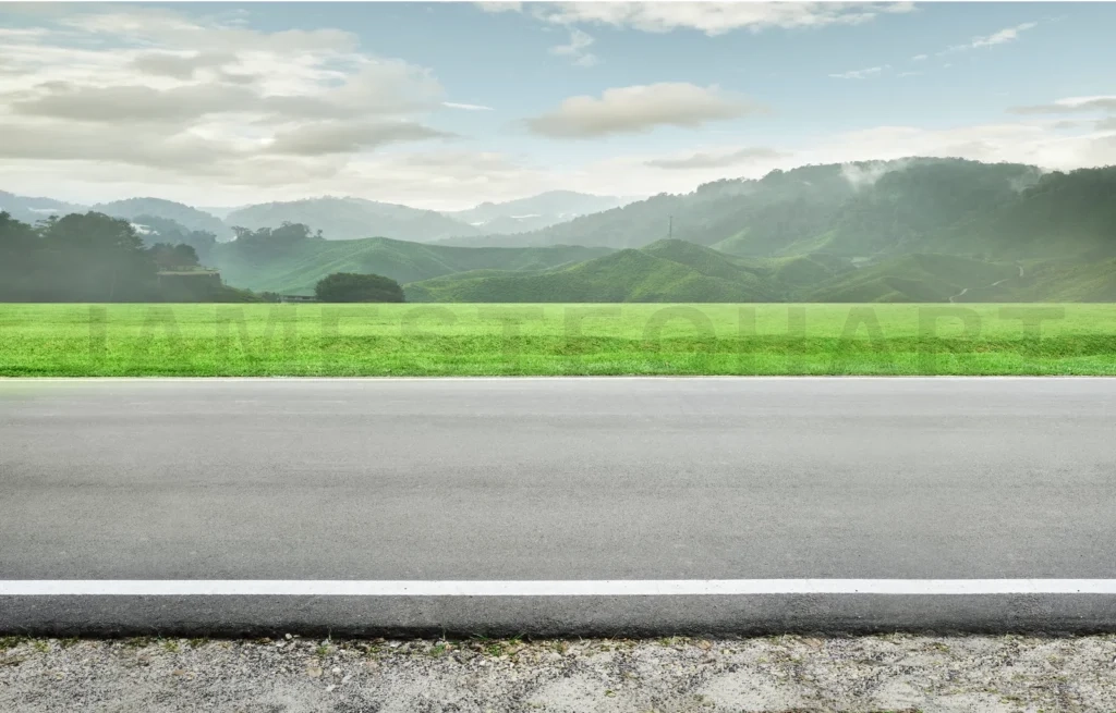 
Empty asphalt road leading to green misty mountains and tea plantation