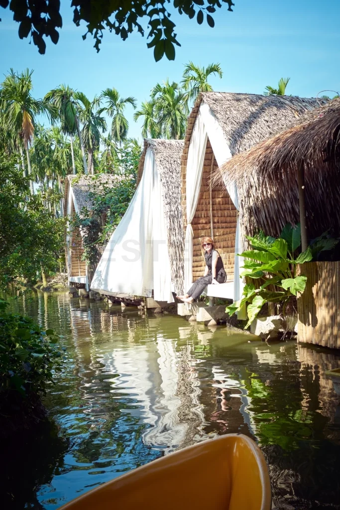 
Female tourist sitting in thatched house by the river in Bangkok