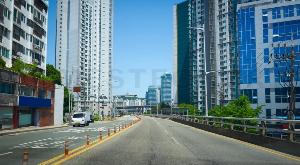 
Urban roadway with skyscrapers under blue sky