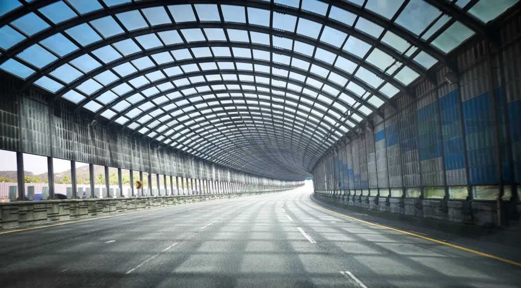 
Futuristic tunnel roadway with blue glass panels