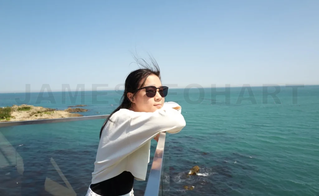 
Young girl enjoying ocean view from balcony