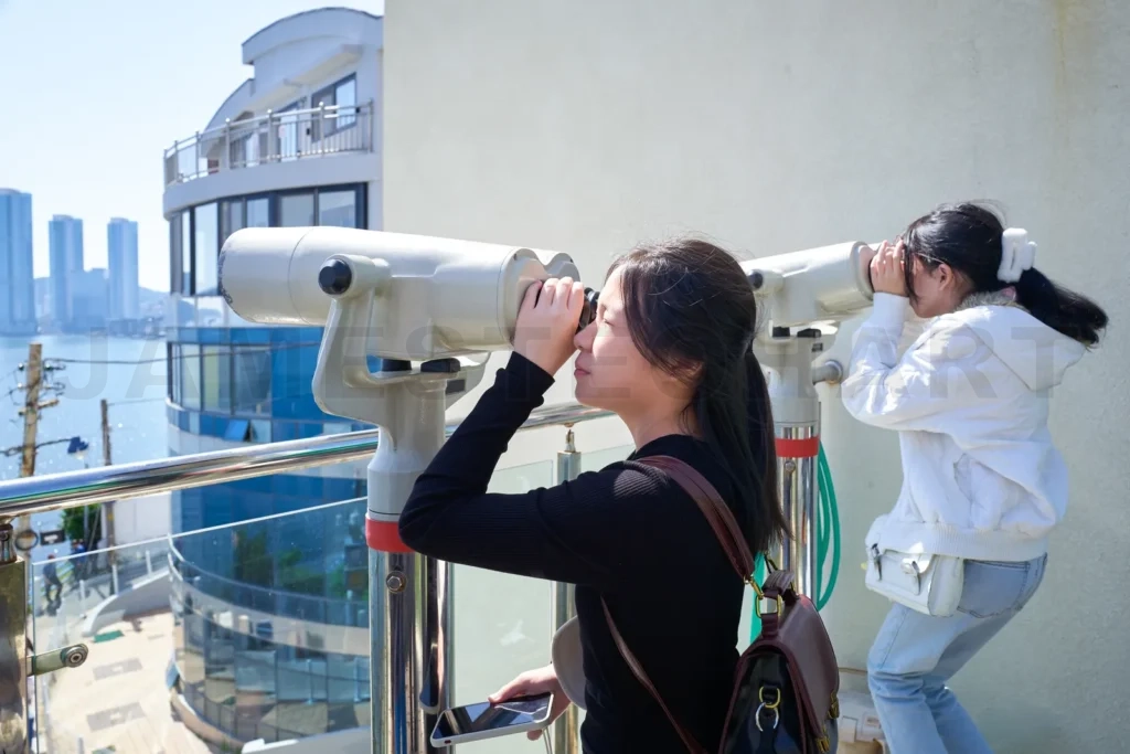 
Tourists using binoculars, enjoying cityscape of busan, south ko