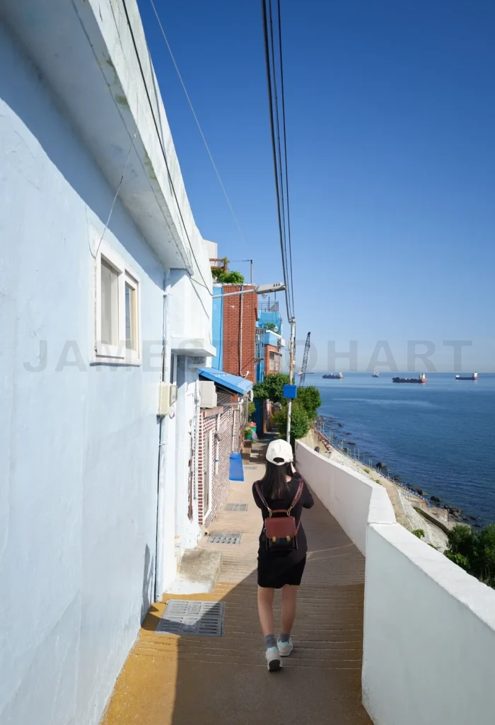 
Young woman walking on a path in huinnyeoul culture village, bus