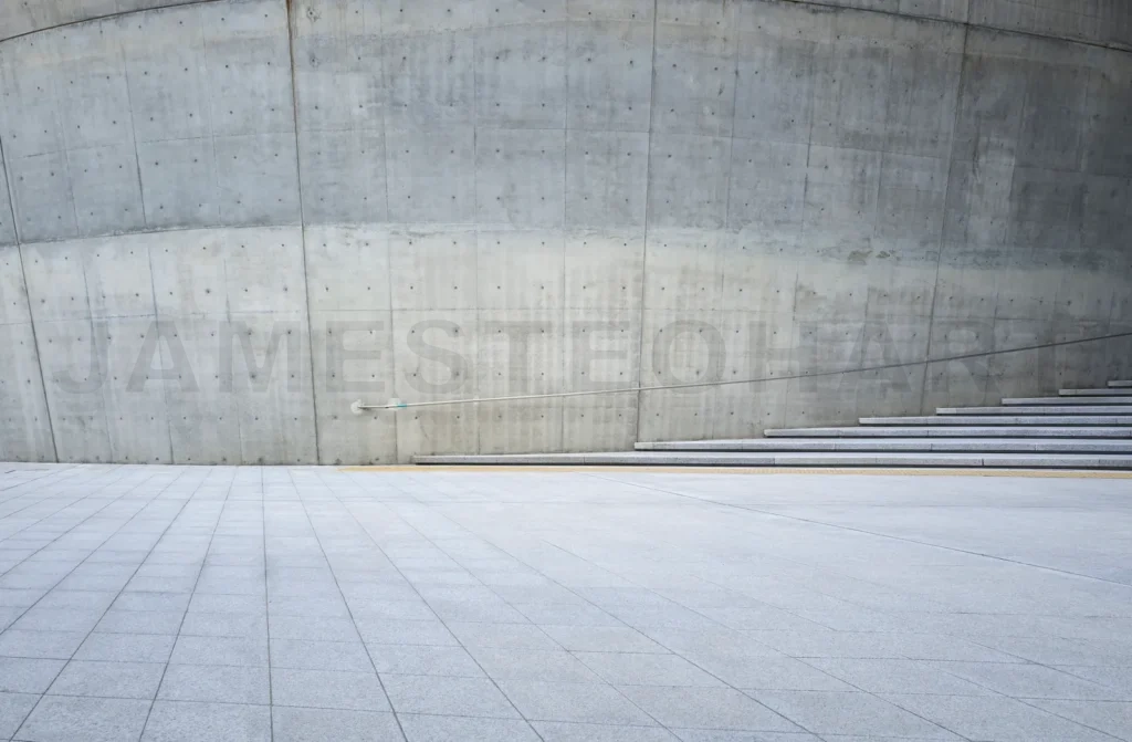 
Empty concrete square with steps and curved wall