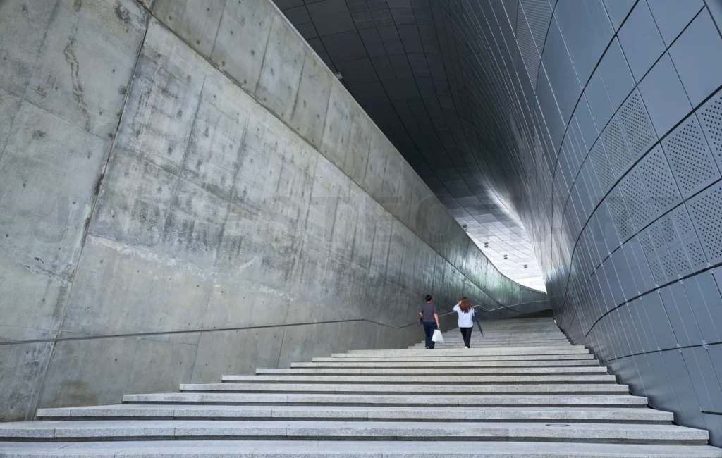 
Couple walking up stairs in modern architectural building