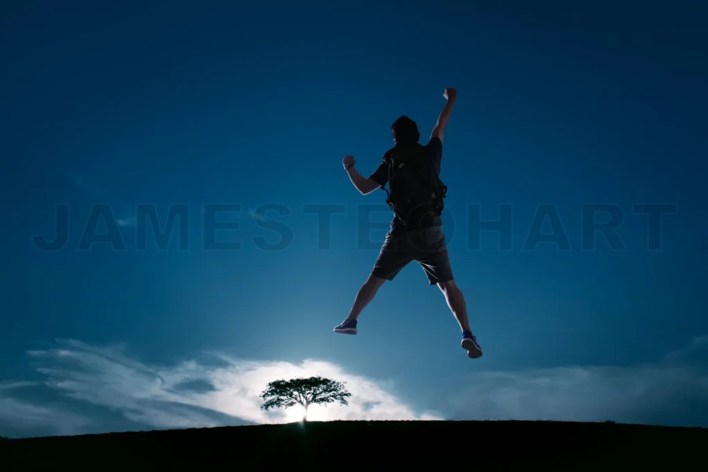 
Silhouette Image Of Young Guy Cheer And Jump Up With Cold Tone Sunset Landscape