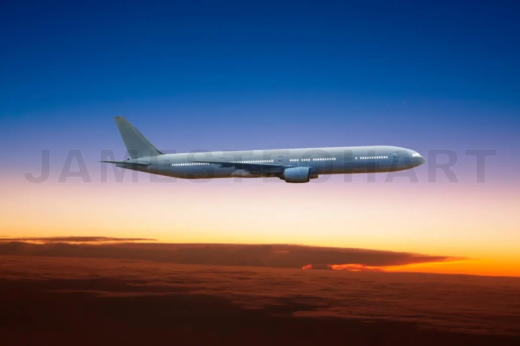 
Airplane Flying High Above The Clouds At Sunset