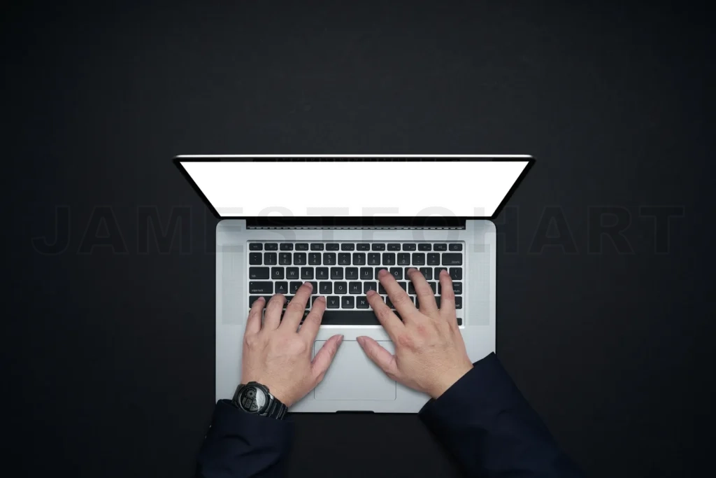 
Hands typing on laptop keyboard with blank screen