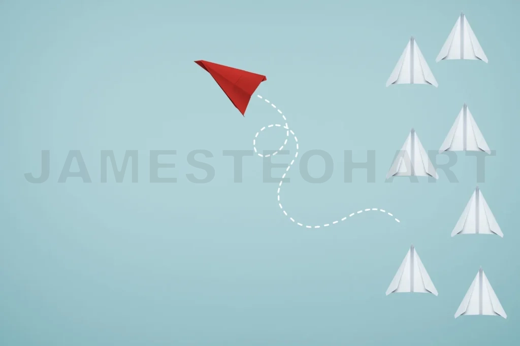 
Red paper airplane breaking away from white group