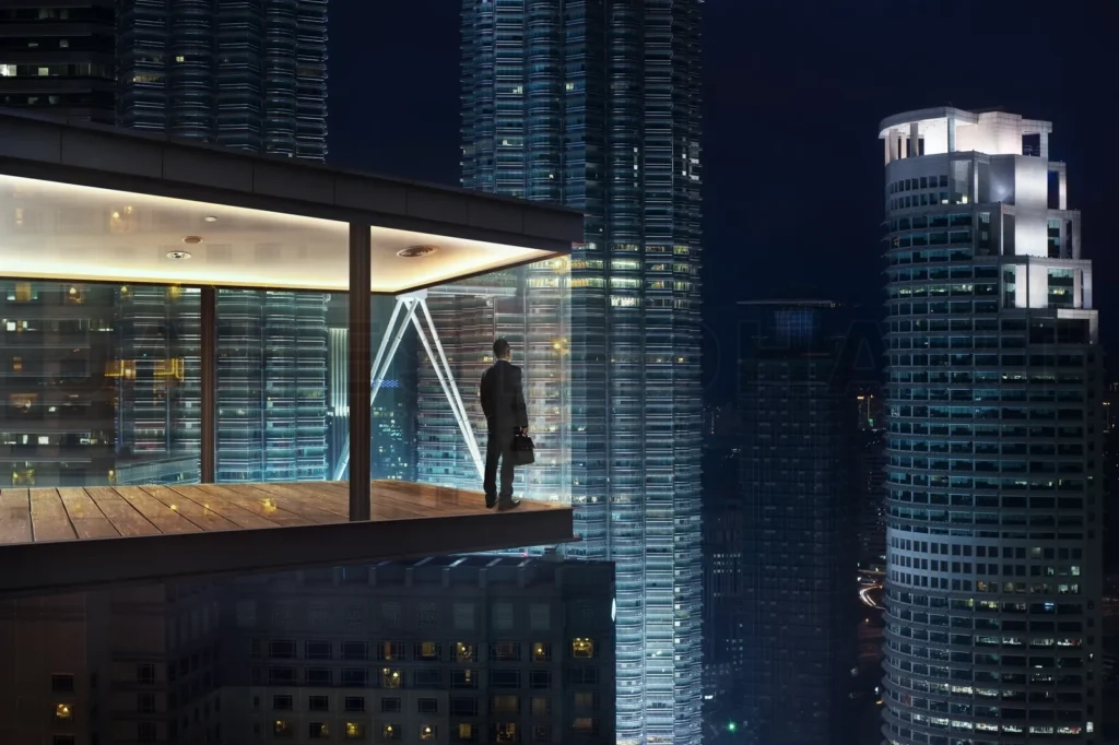 
Businessman In An Modern Sky Office By Night With Beautiful City Skyline View
