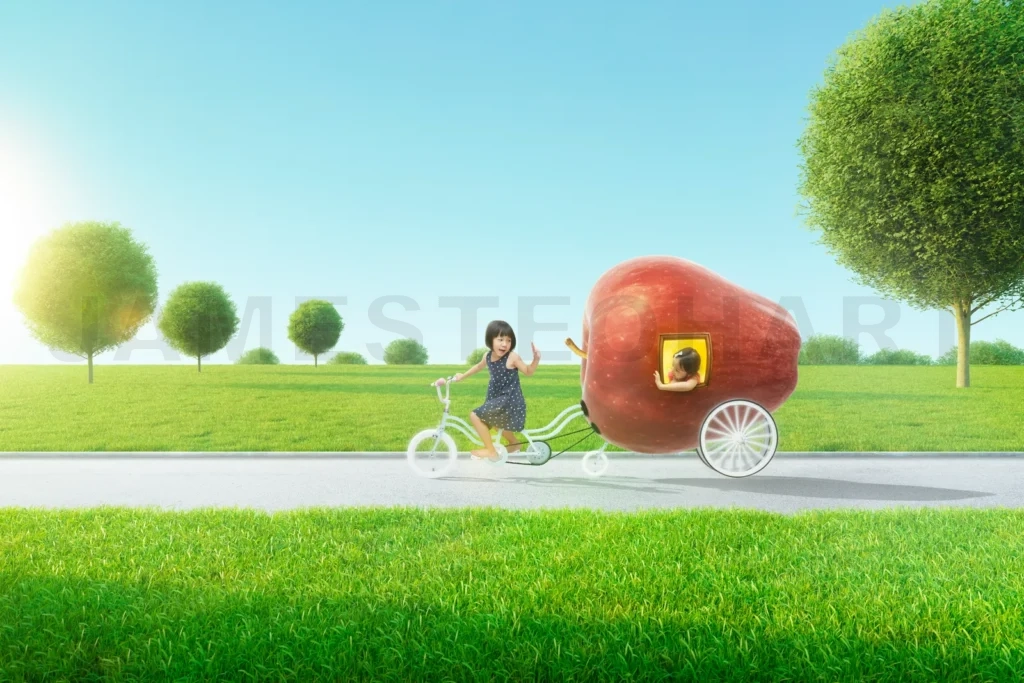 
Two happy children riding giant apple shaped bike trailer on country road